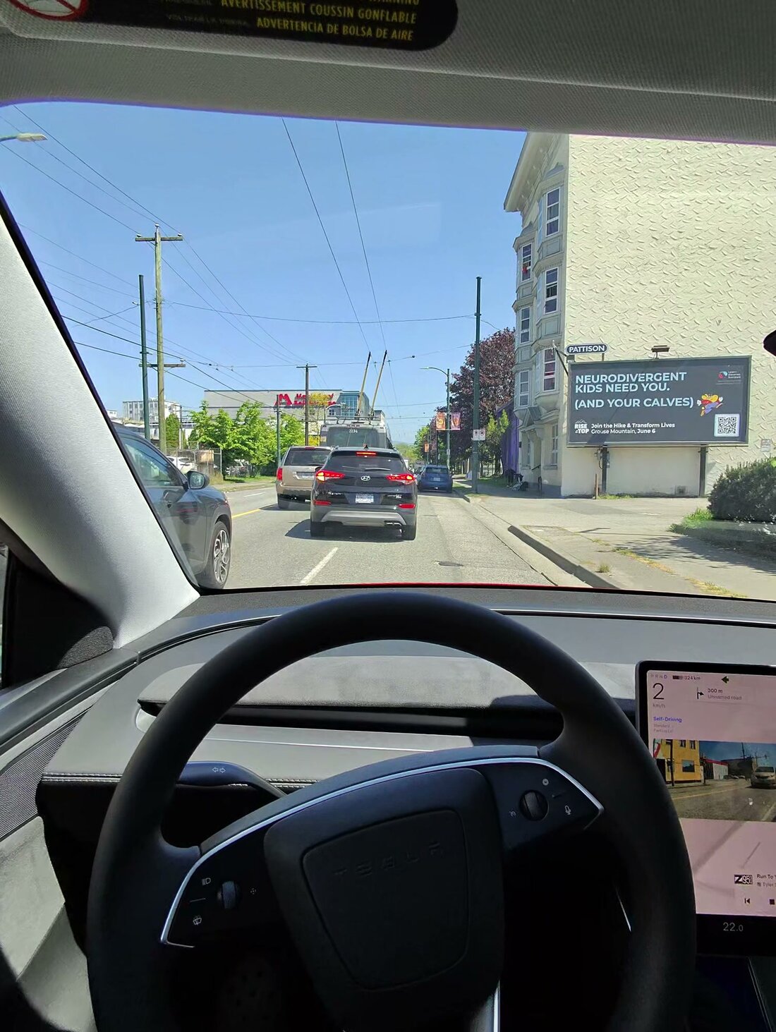 First-person view through Meta Ray-Ban glasses from the Model Y, windshield and center display visible while FSD is engaged in city traffic